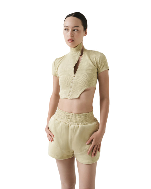 Woman wearing a light green outfit with a plain background