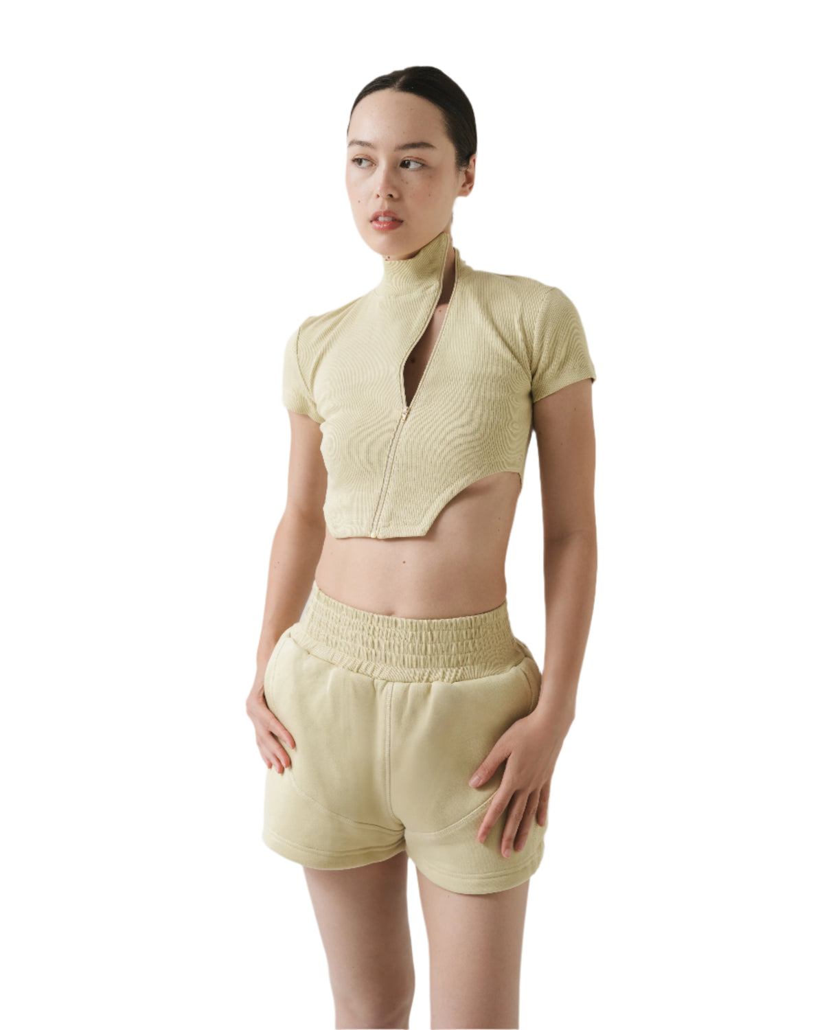 Woman wearing a light green outfit with a plain background